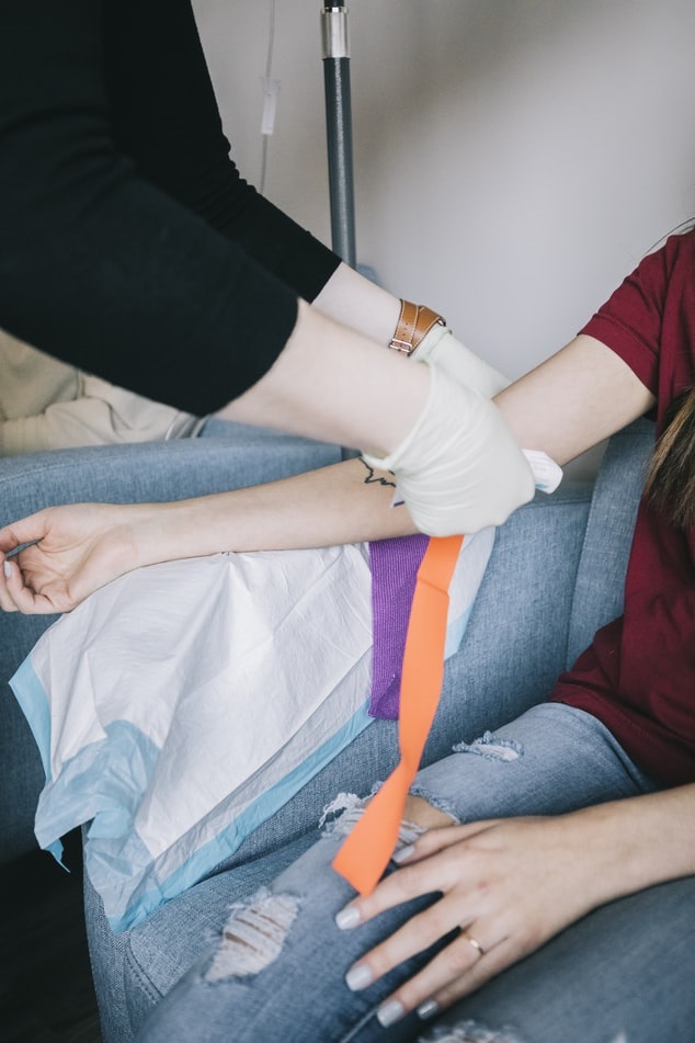 Phlebotomist preparing a patient's arm to draw blood