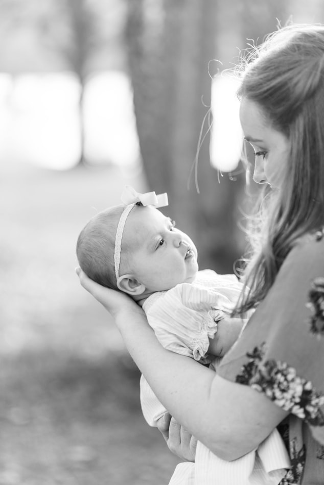 Mother holding her baby and cradling its head while they look at each other