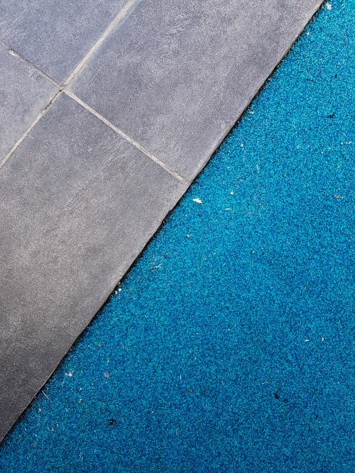 Old carpet partially covered up by new tile flooring