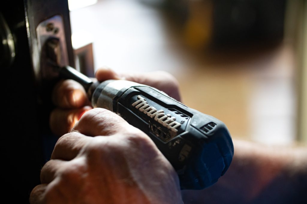 Handyman using a power drill on a door